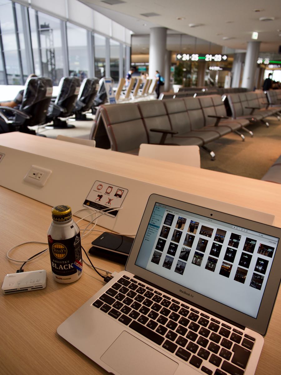 成田空港のPCデスクでMacbookからブログアップしている様子 撮影：DMC-GX8 + LEICA DG 12-60mm