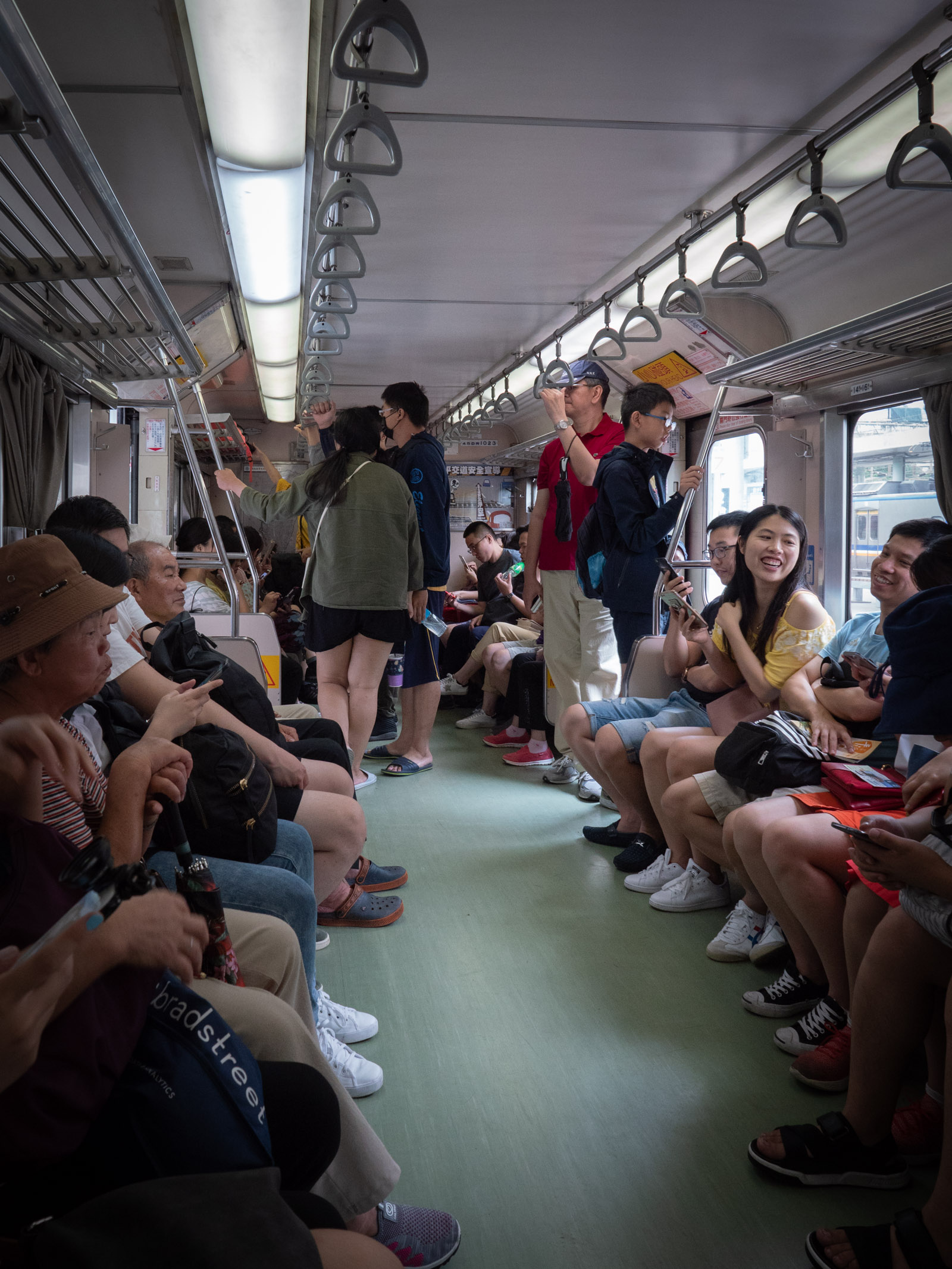 菁桐行き普通列車のロングシートを埋める乗客と数名の立ち乗り客