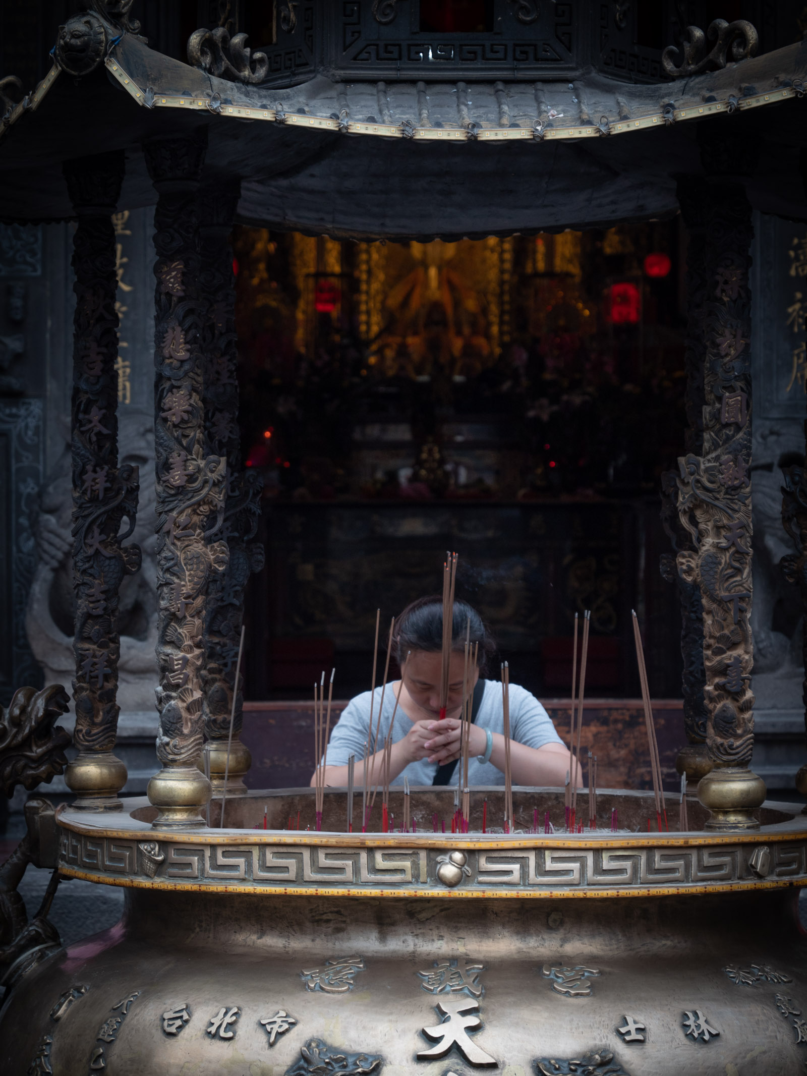 士林慈諴宮で真剣に祈りを捧げる女性